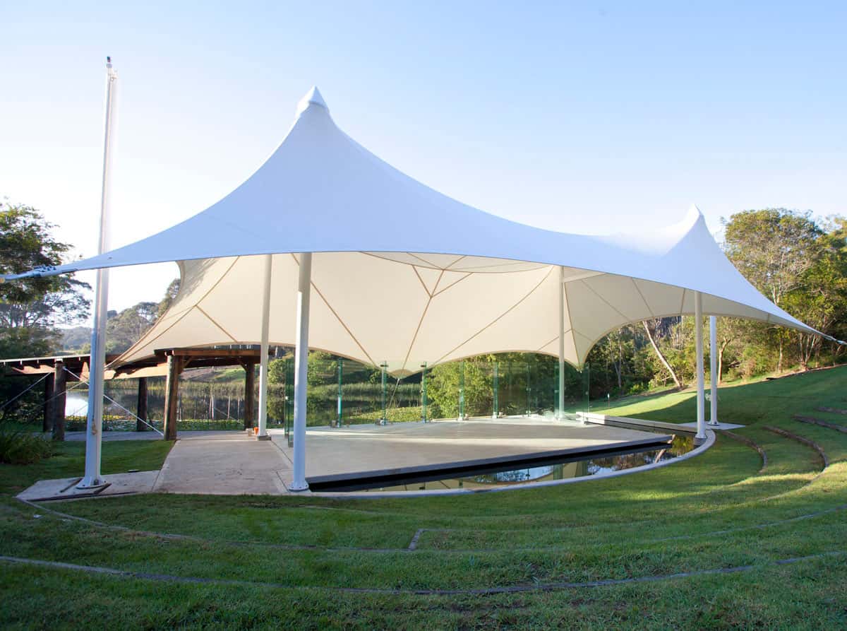Niños jugando de forma segura bajo la protección de una velaria en un parque.