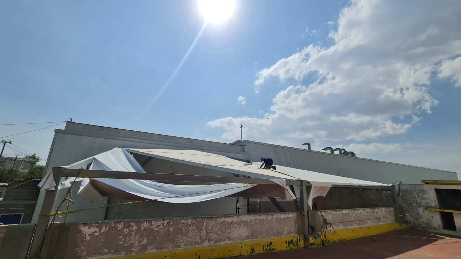 Estructura y lona de alta resistencia de un toldo para patio residencial.