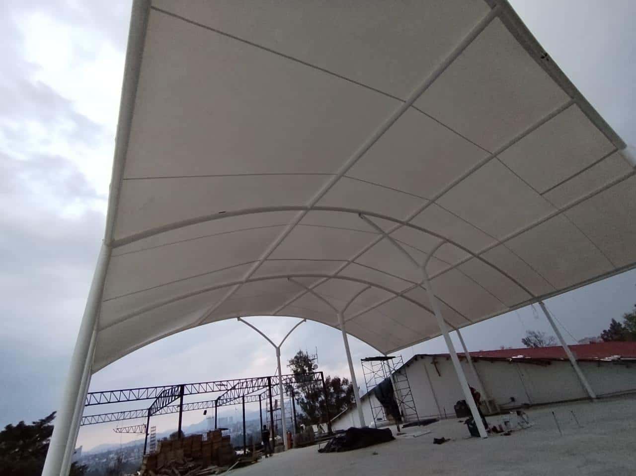 Jugadores en una cancha de pádel con cubierta de tensoestructura.