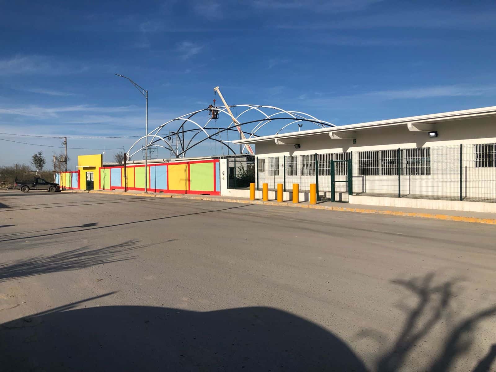 Estudiantes jugando seguros bajo la cubierta protectora del patio.